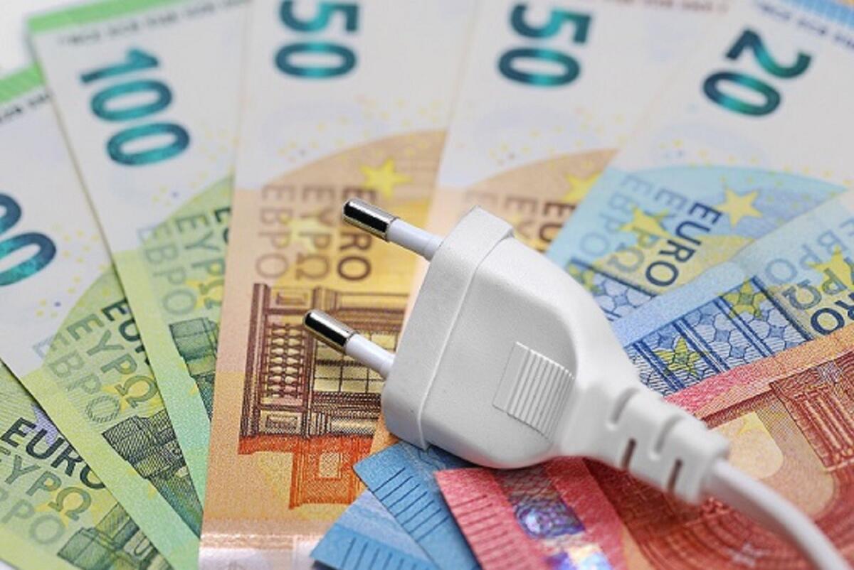 In Calabria bollette in aumento del 30% nel 2021 - white plug on euro banknotes, concept of electricity price increase.