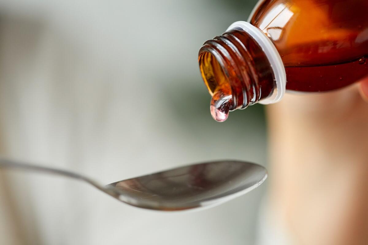 Da nord a sud è caccia all'ibuprofene che non si trova in farmacia - healthcare, treatment and medicine concept - bottle of medication or antipyretic syrup and spoon