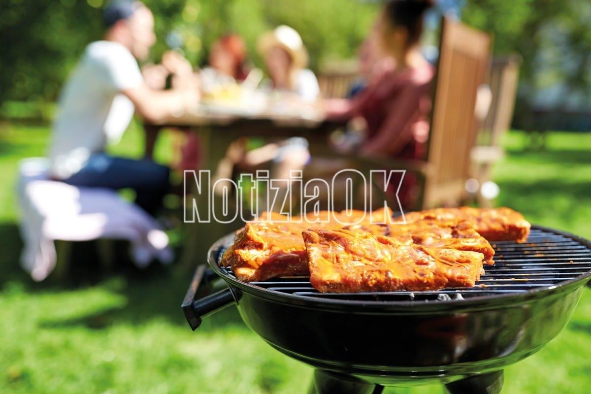 La Pasquetta a mare o in montagna tra gusto e tradizione - leisure, food, people and holidays concept - meat cooking on barbecue grill at summer party