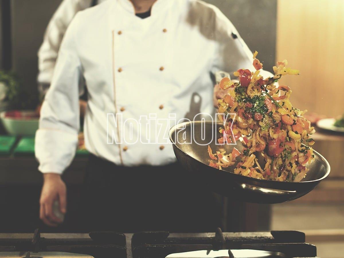 La storia di Toti: "Ho trent'anni. Ho l'autismo e lavoro" - Young male chef flipping vegetables in wok at commercial kitchen