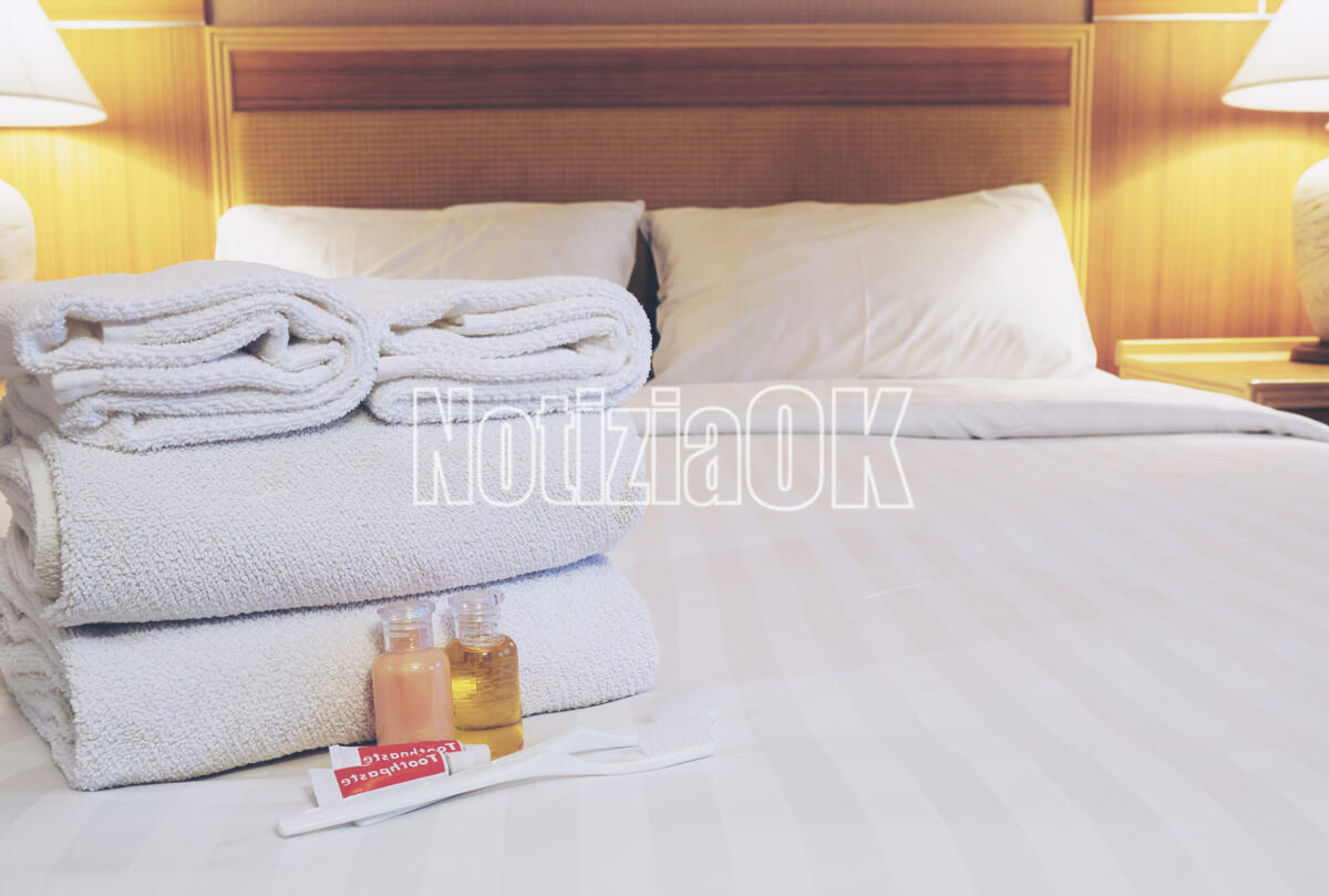 Banca dati delle strutture ricettive, parte la fase sperimentale anche in Calabria - Hotel towel set with toothbrush and toothpaste on white bed