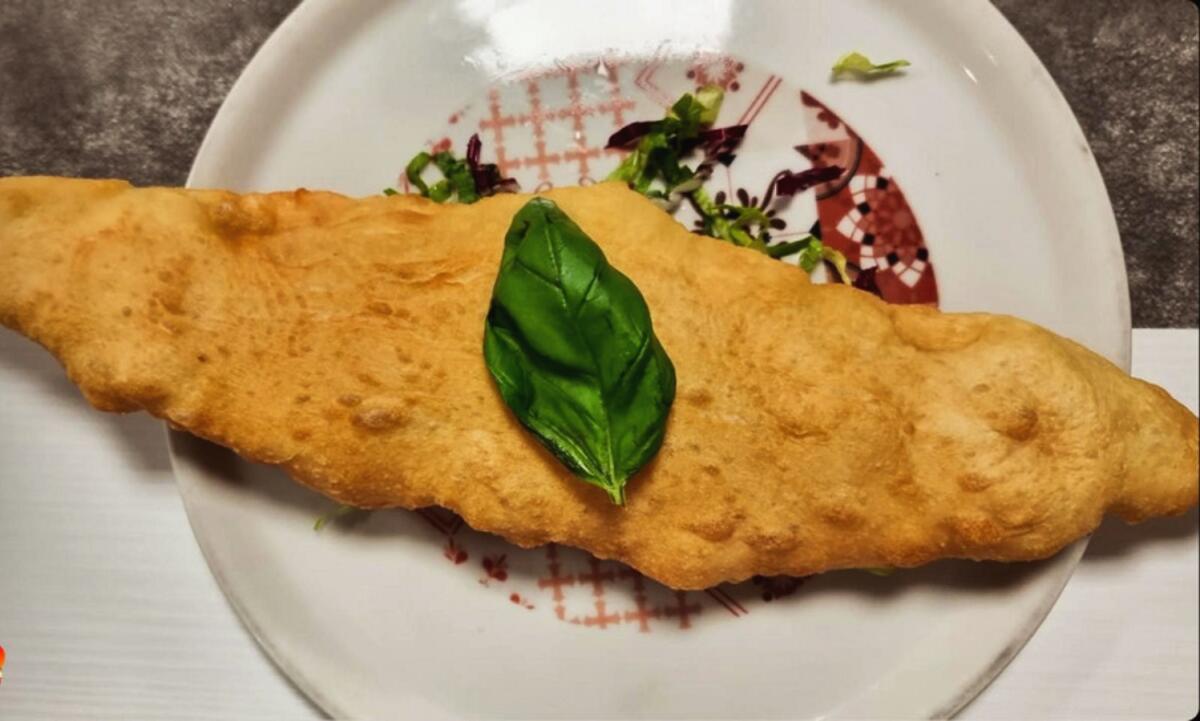 Un morso al sapore alla gustosa pizza fritta di Rende -